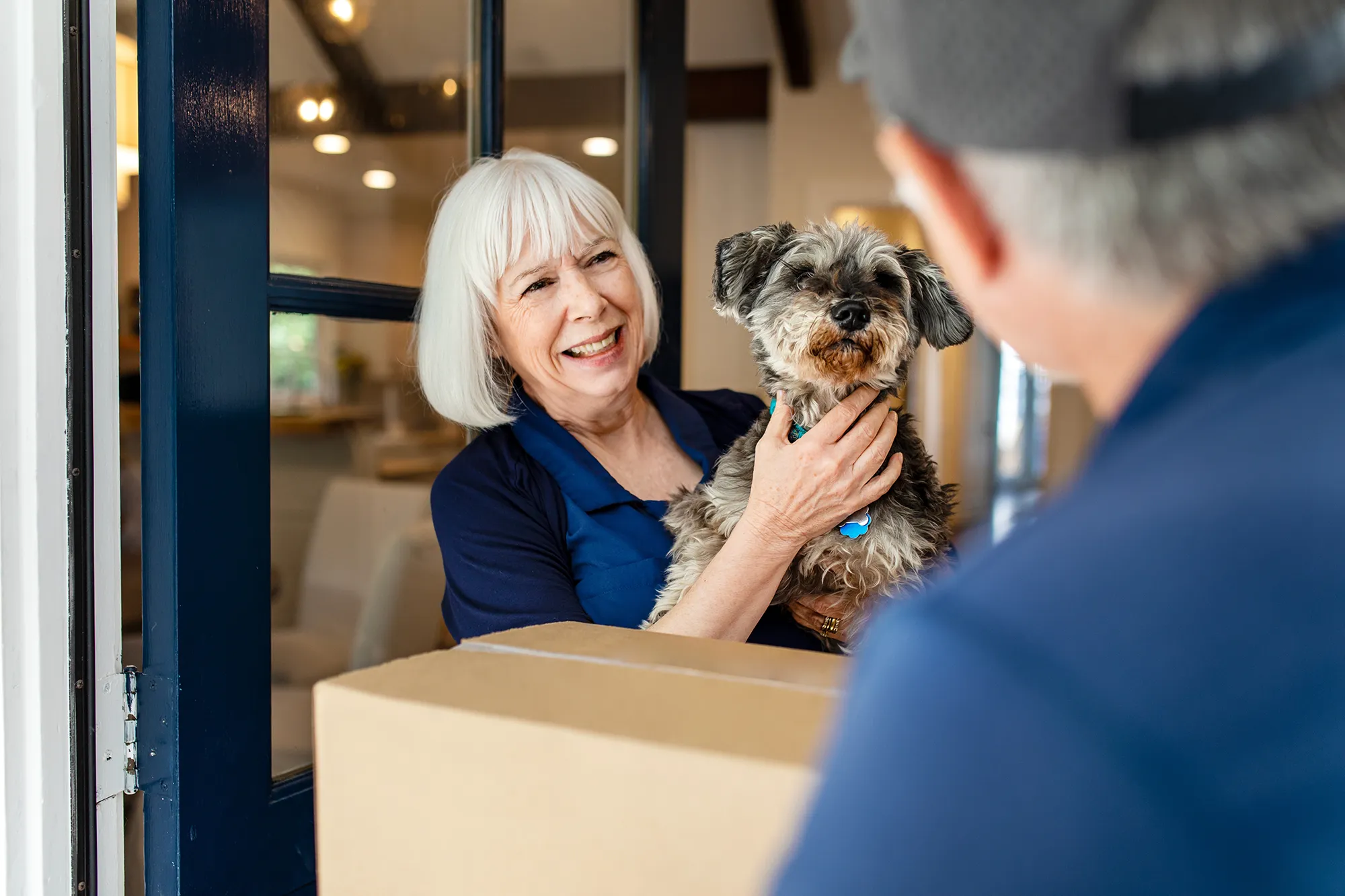 Dog and owner at the front door receiving a delivery